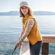 Woman fishing off dock during fall.